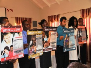 Deputy Premier and Minister of Health in the Nevis Island Administration Hon. Mark Brantley (extreme right) looks on as Windsor University School of Medicine students display posters related to various signs of mental illnesses