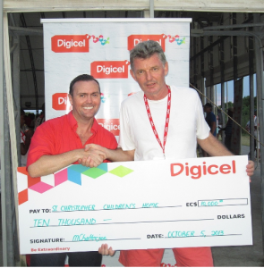 Digicel CEO Johnny Ingle handing over presentational cheque to Sebastian Mottram, Chairperson of the St. Christopher Children’s Home
