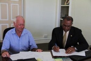 Premier of Nevis Hon. Vance Amory signs documents with Chief Executive Officer of Fly Montserrat Captain Nigel Harris at the Ministry of Tourism’s office at Bath Hotel, Bath Plain on December 16, 2013. 