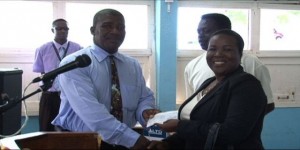 Permanent Secretary in the Ministry of Education Lornette Queeley-Connor hands over a cheque of £600 donated by the UK-based St. Kitts/Nevis & Friends Association to Principal of the Charlestown Secondary School Edson Elliott at the Charlestown Secondary School on March 26, 2014