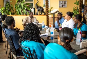 Prime Minister Denzil Douglas sits with staff of the Royal St. Kitts Hotel 