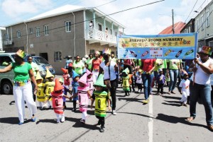 Mrs Patricia Dasent (extreme left) leads children and staff members of Steppin’ Stone Nursery during the Child Month Parade that was held in Charlestown on Friday June 6.