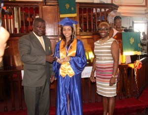 (L-R) Principal of the Charlestown Secondary School Edson Elliott presents Valedictorian Brianna Brantley with The Principal’s Medallions Excellence Award while Presenter Mrs. Marva Roberts looks on