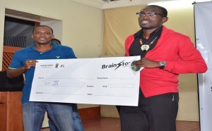 Rodney Browne (left) of Arts Arise handing over cheque to James Galloway the winner of the Brainstorm Spoken Word Slam
