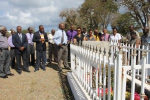 At the graveside of the late Malcolm Guishard at Bath Cemetery to honour his memory on June 11, 2015 are (front row l-r) Theodore Hobson, Premier of Nevis Hon. Vance Amory, Deputy Premier Hon. Mark Brantley, Cabinet Secretary Stedmon Tross, Widow of the late Malcolm Guishard Yvonne Guishard and their daughter Shanelle and Legal Advisor in the Nevis Island Administration Colin Tyrell