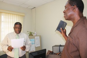  Nelson Stapleton (r) being sworn in as a Registration Officer for Constituencies 10 and 11 by Supervisor of Elections Elvin Bailey at the Electoral Office on Nevis on July 20, 2015
