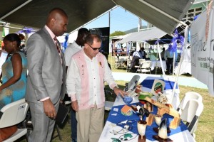 Minister Richards pays keen attention as an exhibitor explains the contents in his booth.