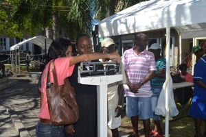 Head of the Nevis Health Promotion Unit Nadine Carty-Caines weighs a member of the public for the body mass index (BMI) information at the unit’s free health screening activity on April 07, 2016, at the War Memorial in Charlestown in observance of World Health Day 