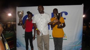 Director of Sports on Nevis Jamir Claxton presents trophies to (l) Tiana Liburd of the St. James Primary School and (r) Queleel Roberts of the Elizabeth Pemberton Primary School for Best Individual Performance at the 24th Gulf Insurance Athletics Championships at Elquemedo T. Willet Park on March 30, 2016 