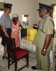 Ms Iris Browne of Zion Village recieving a gift basket from officers of the Nevis Division as part of Police Week Celebrations.