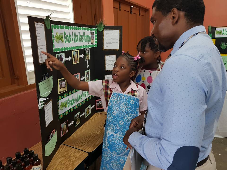 Dr. Drew congratulates Cayon Primary students