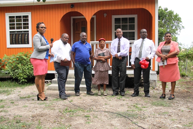 Ms. Lorraine Cassandra Phillip accepts keys to a new home NIA provides in Fountain Village